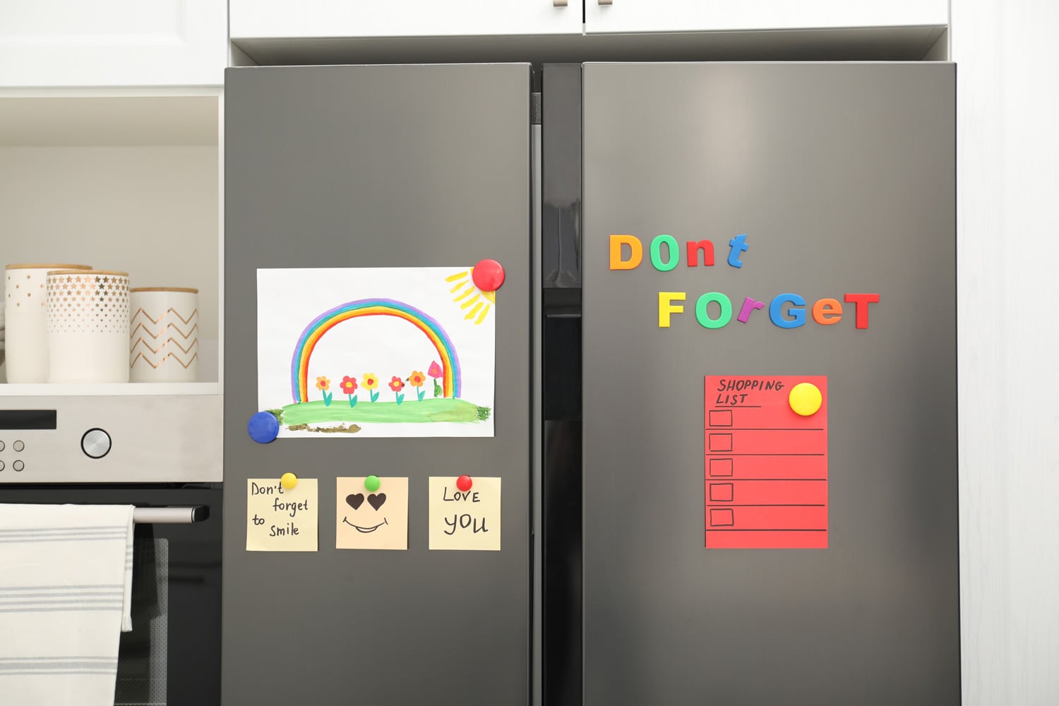 Modern refrigerator with child's drawing, notes and magnets in kitchen