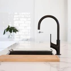 Monochrome kitchen detail of black gooseneck tap set in a white marble counter top, How To Remove Kohler Kitchen Faucet?