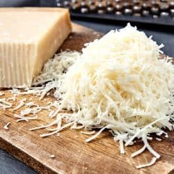 A piece and grated parmigiano reggiano or parmesan cheese on wood board, Can You Grate Cheese Ahead Of Time?