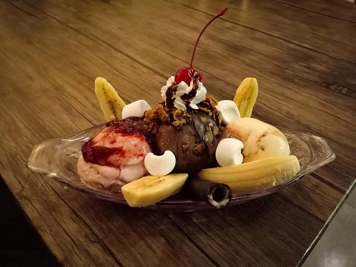 Split banana ice cream served with cherry fruit and banana pieces
