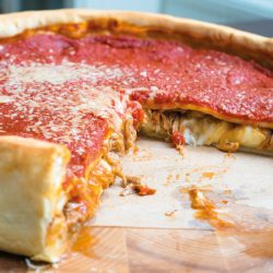Top view of Chicago pizza. Chicago style deep dish italian cheese pizza with tomato sauce and beef. How Deep Is A Chicago Deep-Dish Pizza 