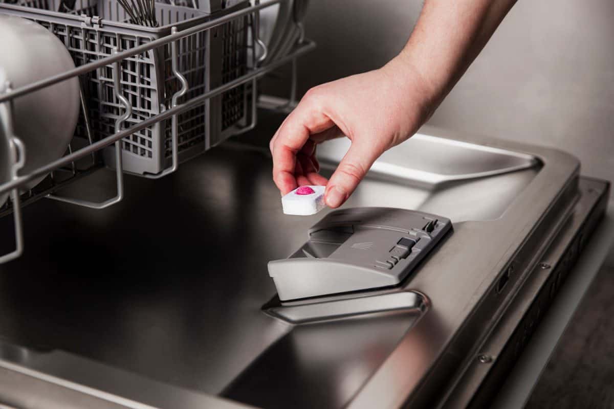 Woman putting a detergent ball onto the dishwasher