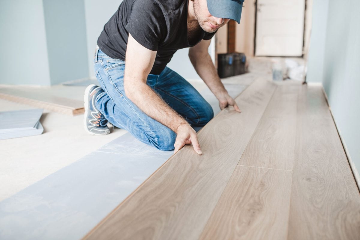 Worker placing laminated flooring on the kitchen flooring
