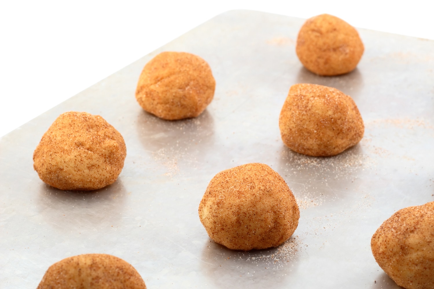 A baking sheet with cookie dough balls.