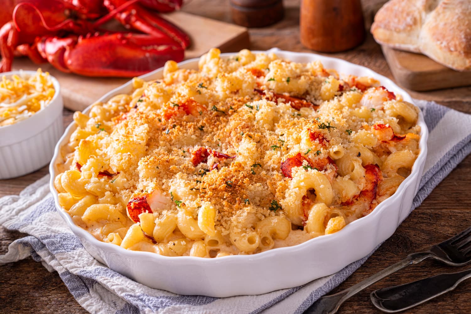 A delicious lobster macaroni and cheese casserole on a rustic wood table top.