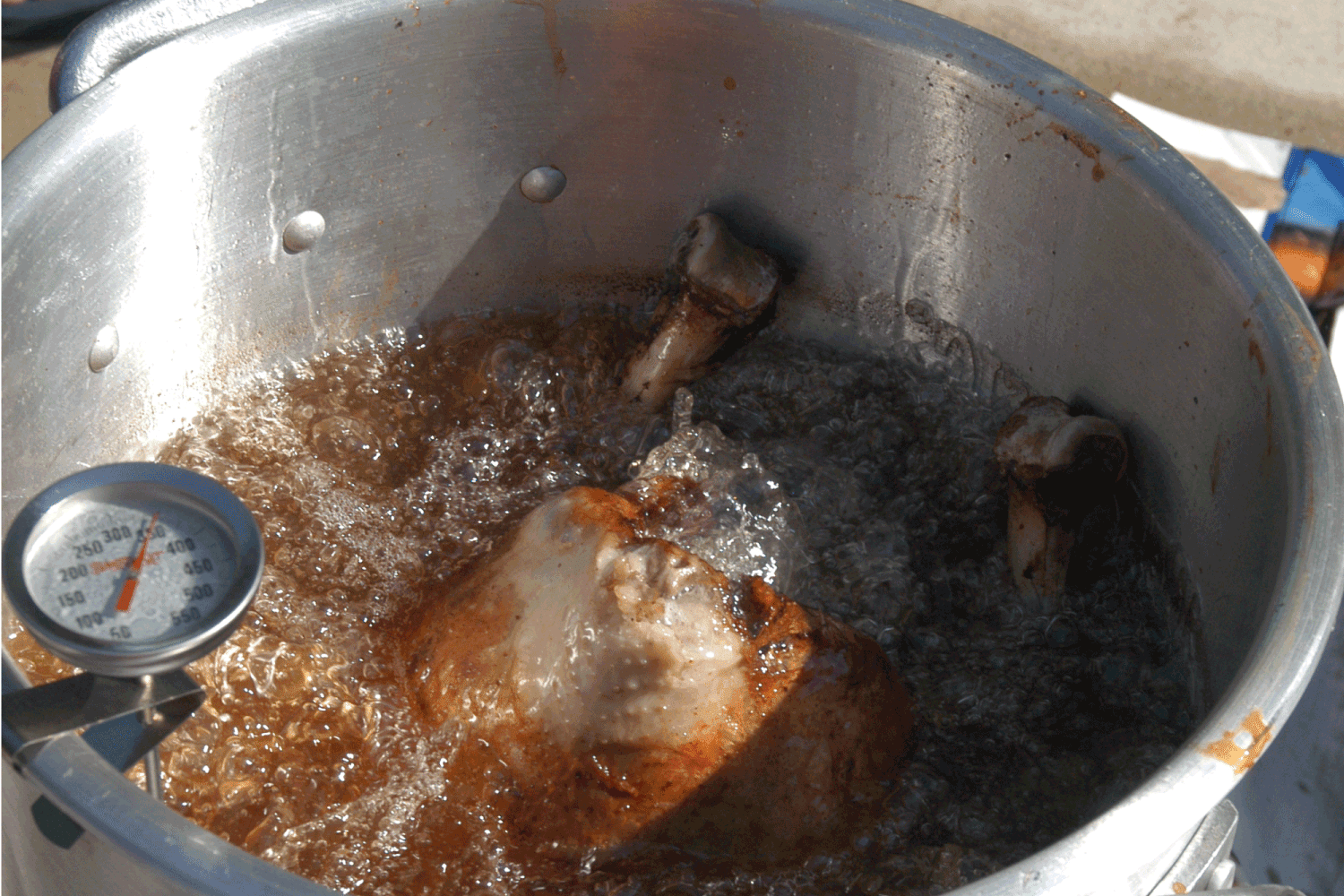 A full-size turkey being fried in peanut oil.