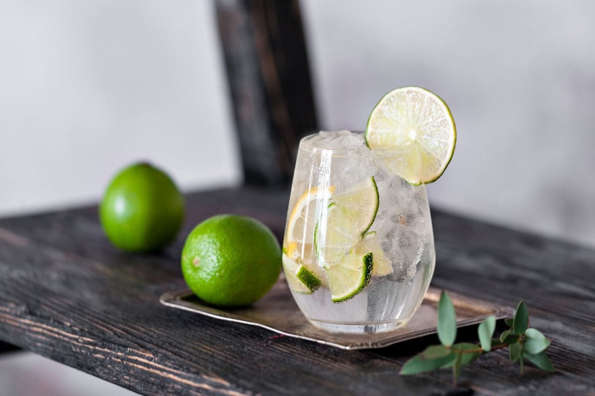 A glass filled with vodka and lime