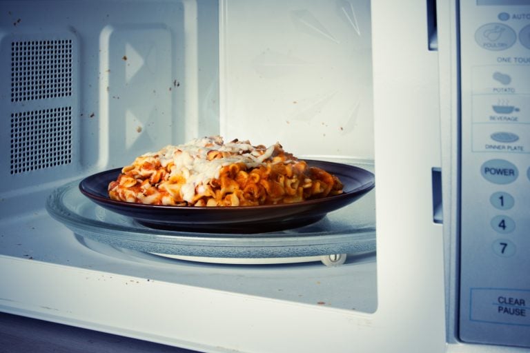 A plate of leftover lasagna is reheated in a microwave - How Long To Bake Lasagna