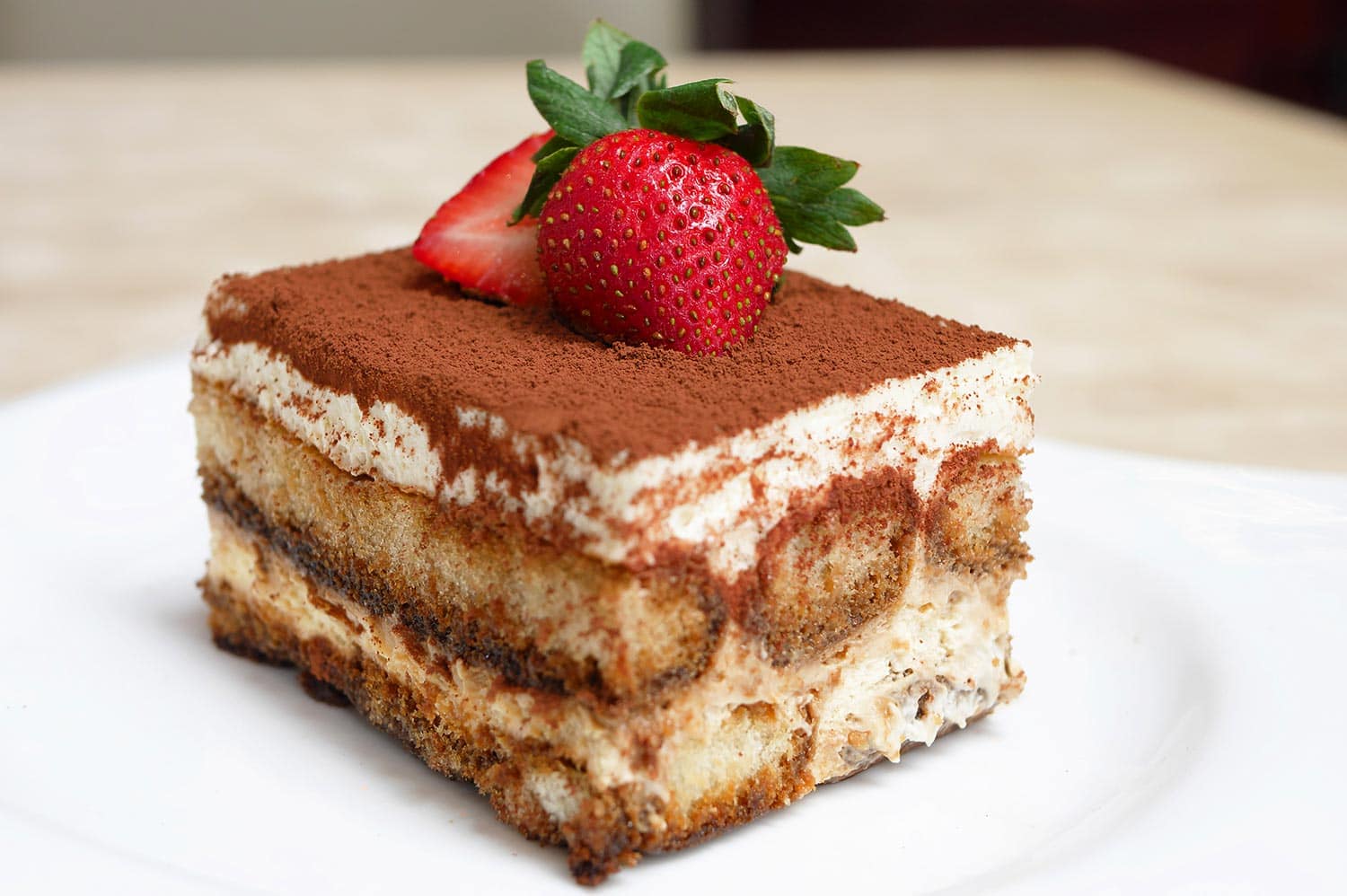 An Italian dessert consisting of layers of sponge cake soaked in coffee and brandy or liquor with powdered chocolate and mascarpone cheese