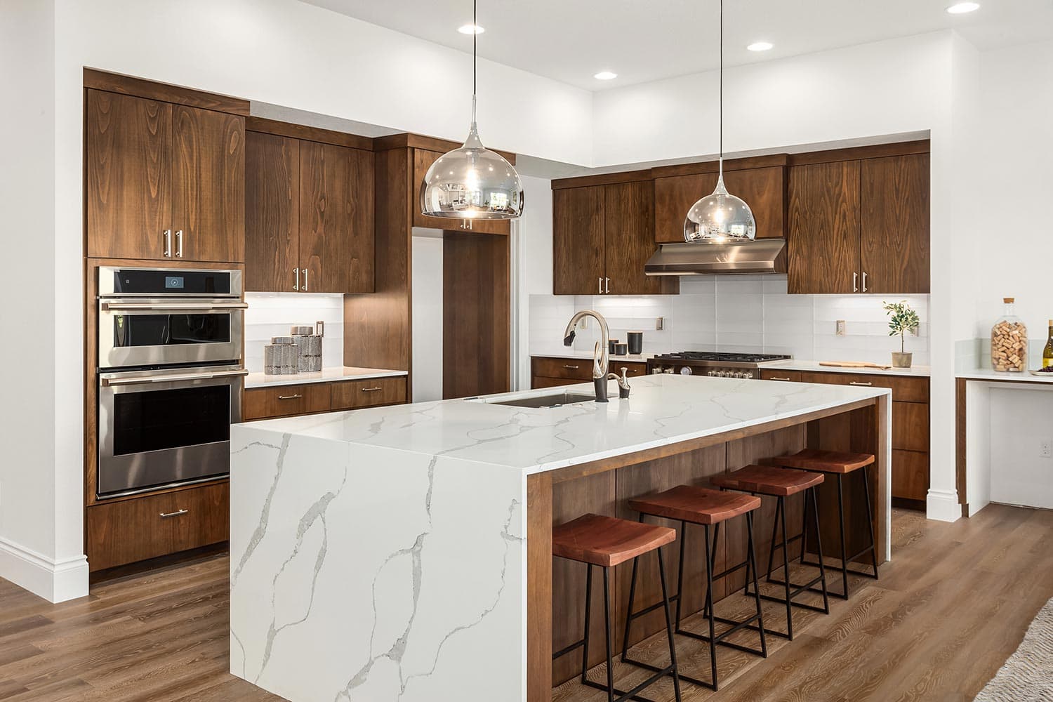 Beautiful kitchen in new luxury home with island, pendant lights, and hardwood floors