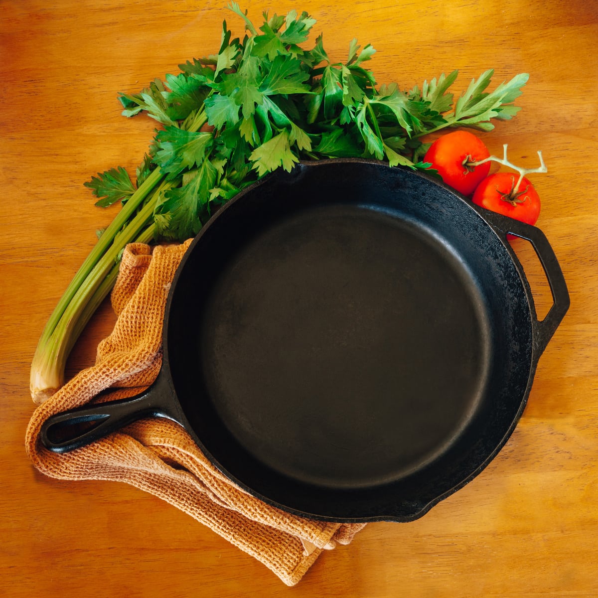 Cast iron pan and vegetables on a wooden table