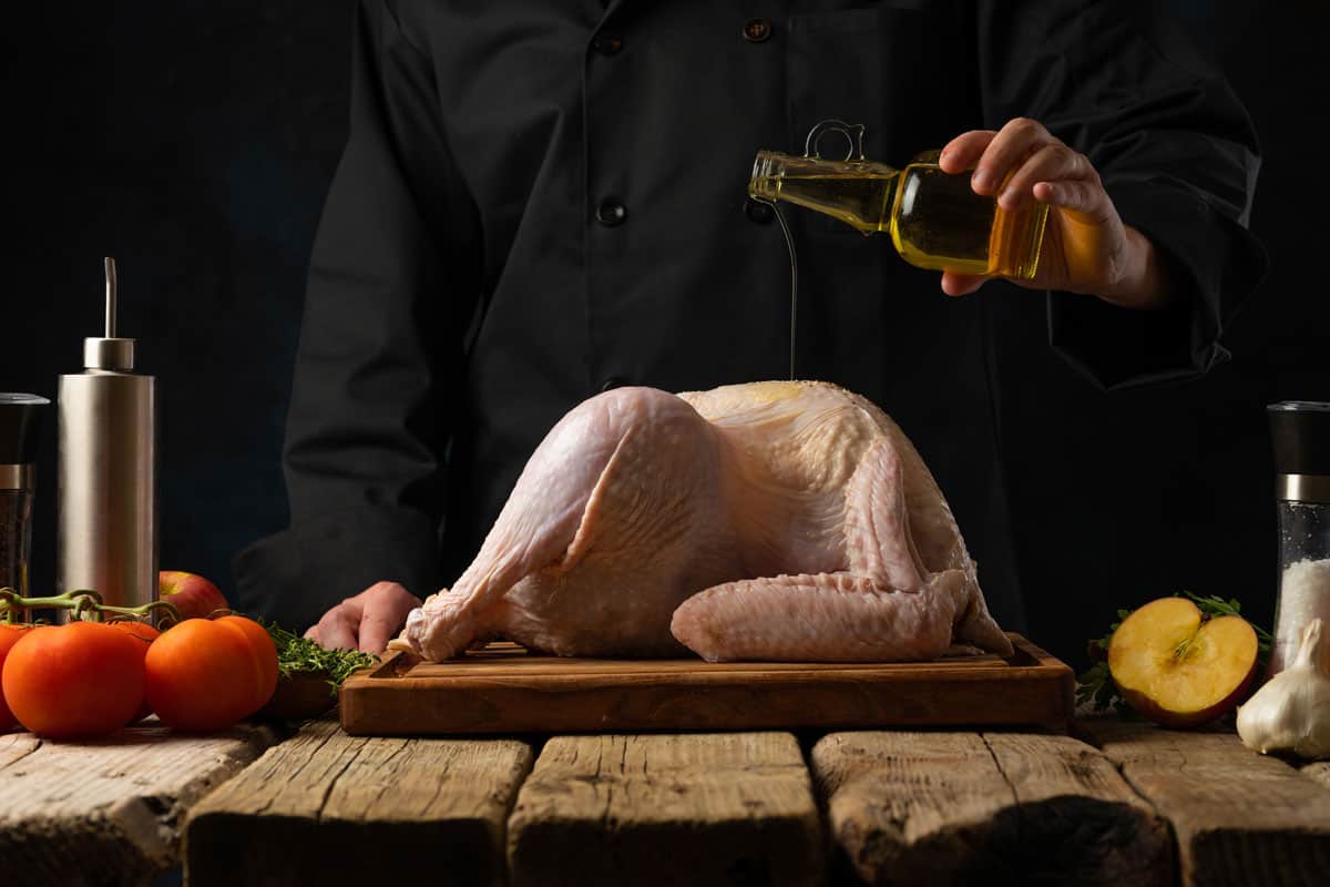 Chef pouring an olive oil in a turkey