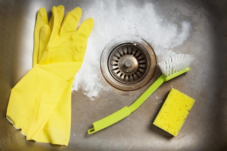 Cleaning products and a rubber gloves in a dirty kitchen sink, How To Clean A Kitchen Sink Drain And Stopper