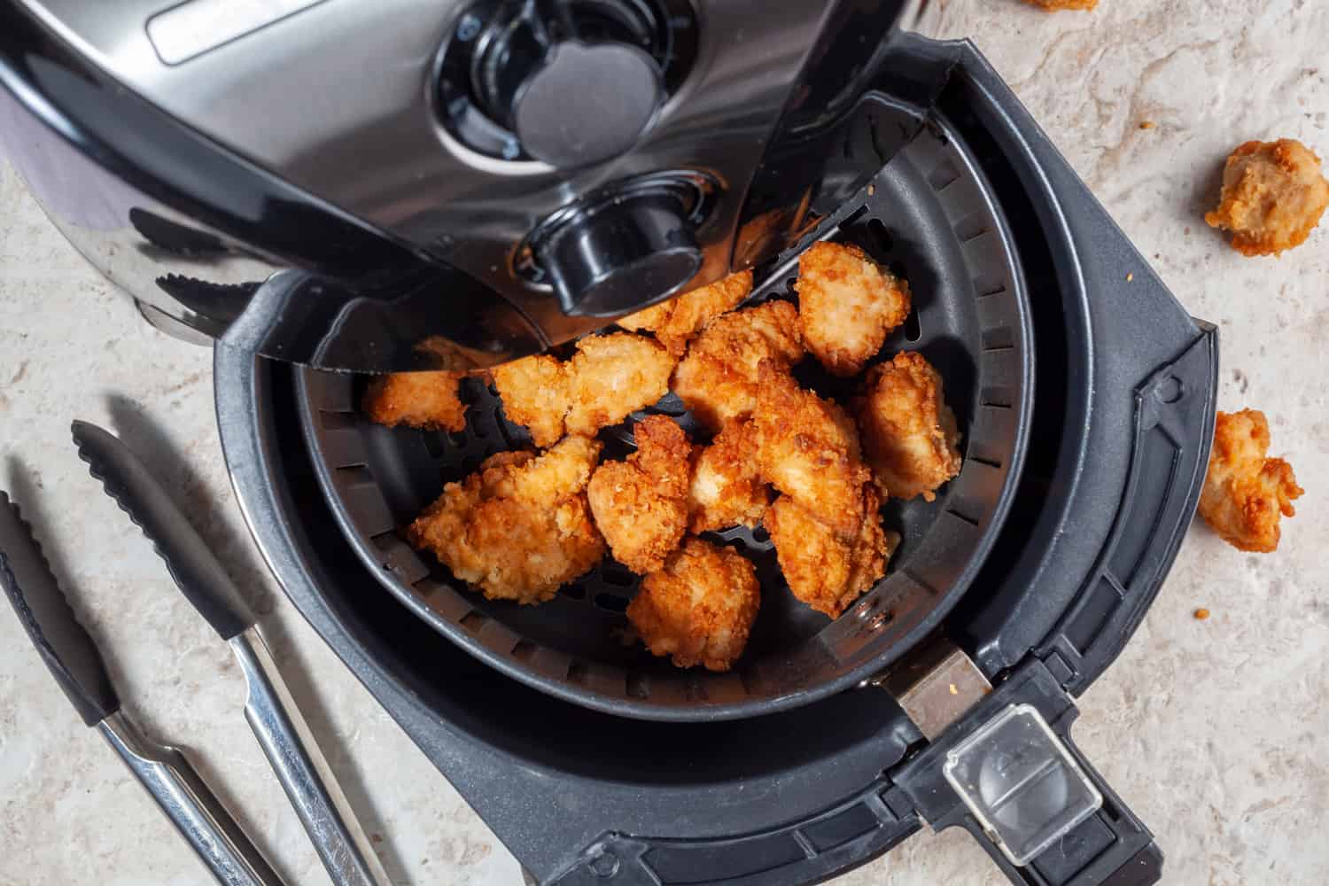 Close up flat lay image of an air fryer oven on kitchen countertop.