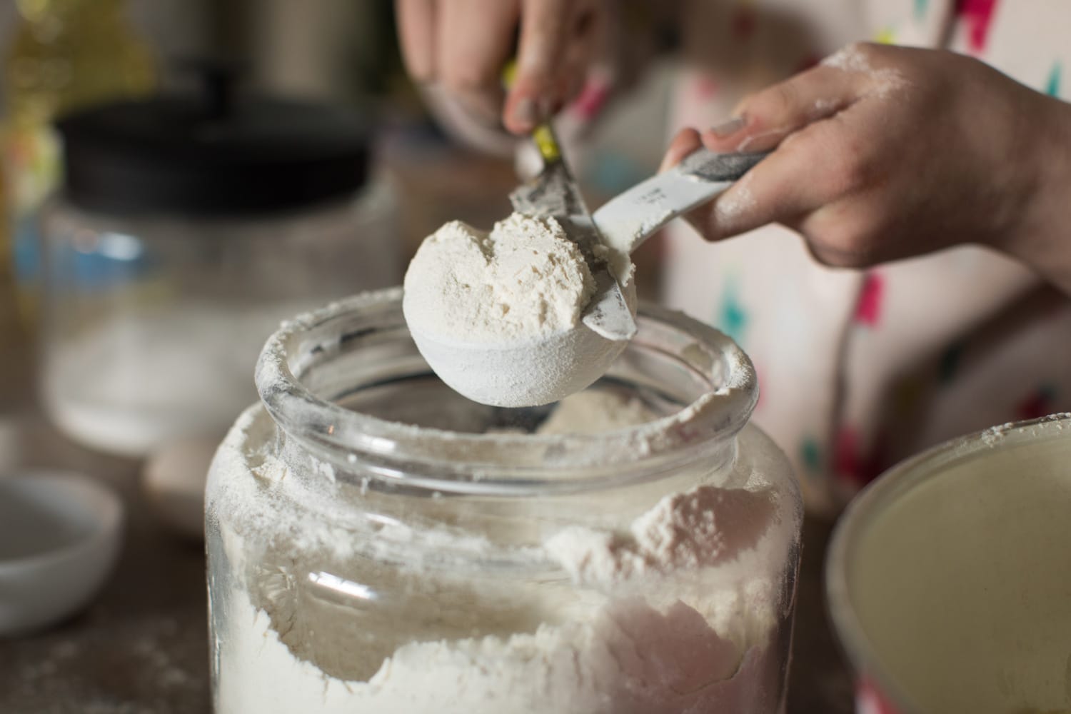 Close up of young girl's hands measuring flour while baking