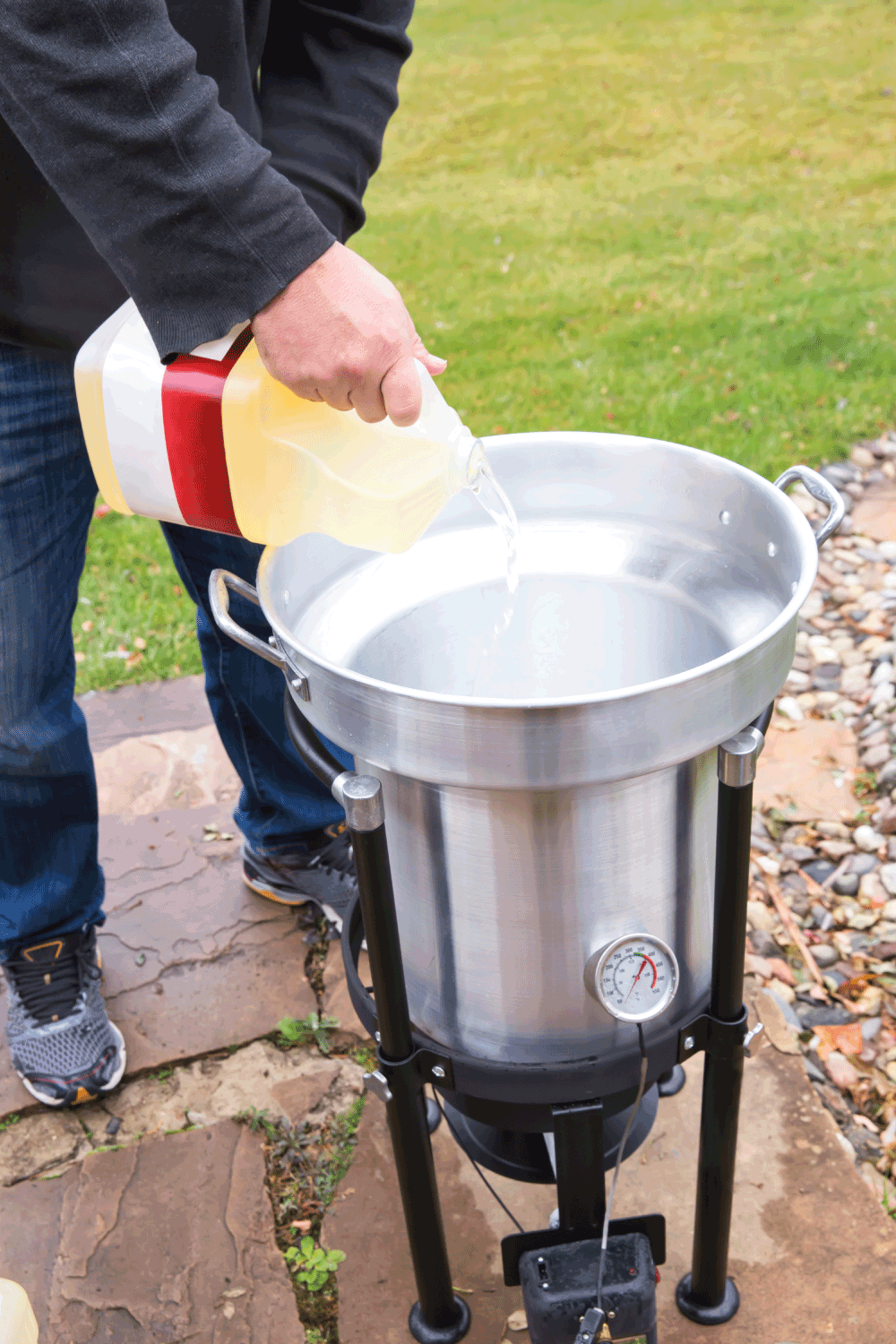 Cooking oil being poured into an outdoor deep fryer