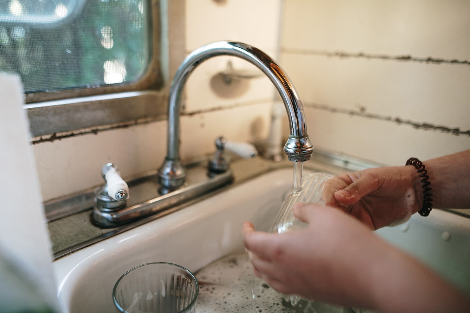 Detail of a person washing dishes inside a motor home