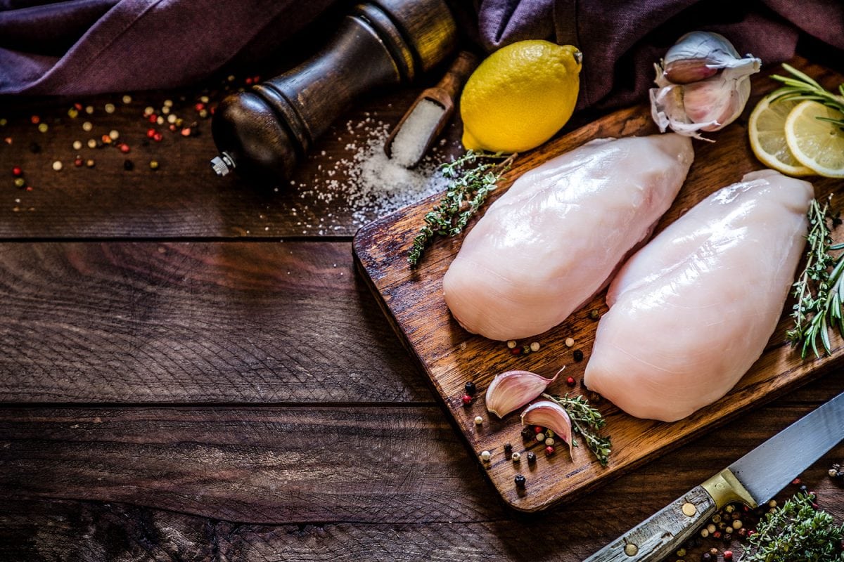 Filleted chicken breasts on chopping board