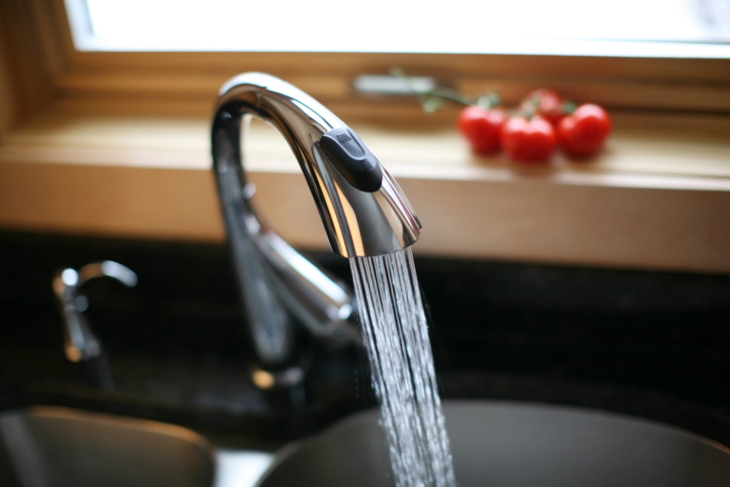 Kitchen faucet spraying fresh, clean cold water.