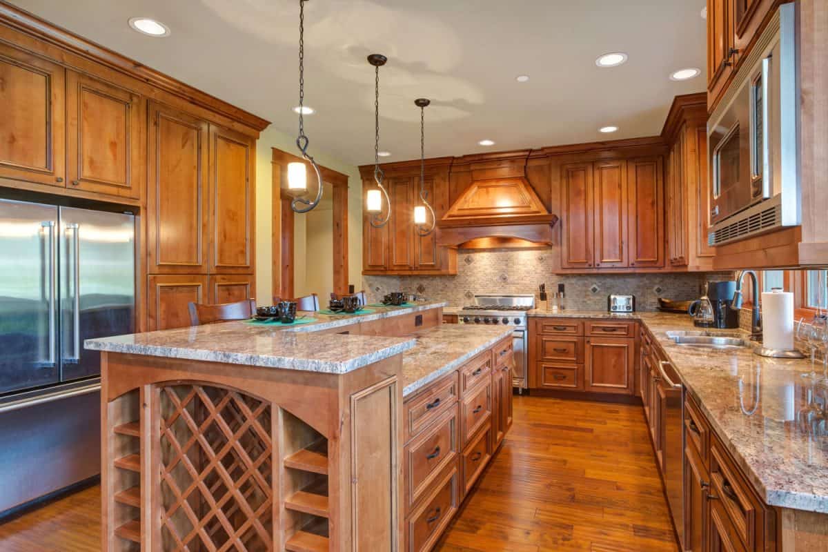 Luxurious wooden and rustic inspired kitchen with maple cabinets and marble countertops