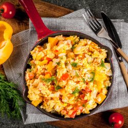 Mexican food recipes, Revoltillo de Huevos, Scrambled Eggs a la Dominicana, in portioned skillet, on dark stone table,copy space top view - Why Are My Scrambled Eggs Watery? [And How To Fix That]