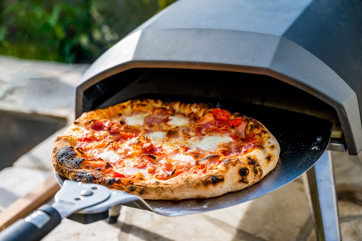 Making homemade pizza in portable high temperature gas pizza oven