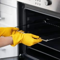Man cleaning oven in kitchen, closeup, Can You Leave Oven Racks In During Self Clean?