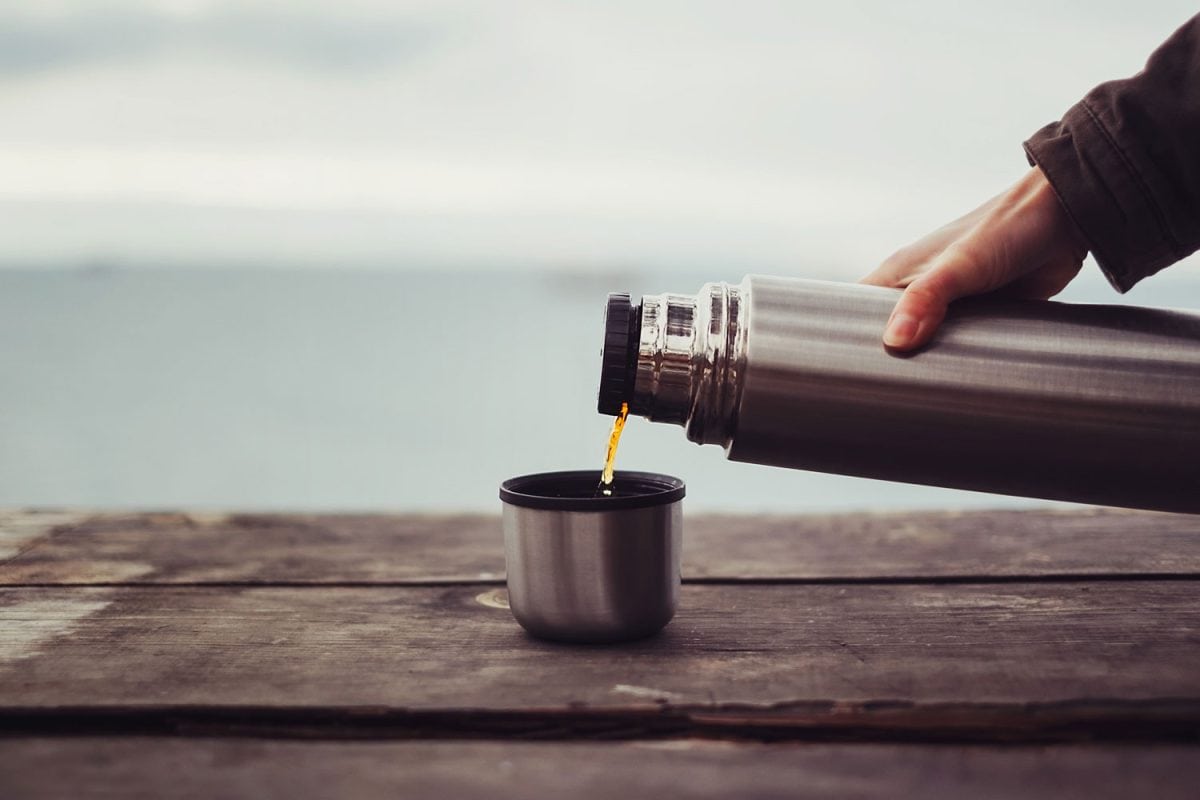 Man pouring a cup of coffee from his flask