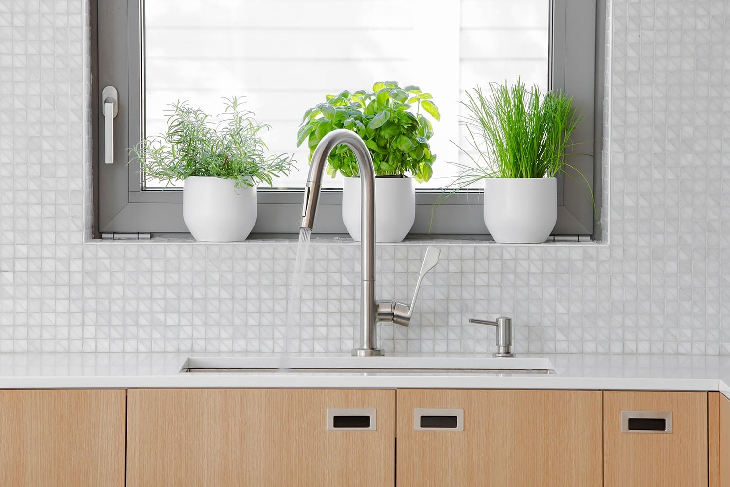 Modern kitchen stainless steal faucet with water running into sink