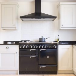 Modern modular kitchen interior in black and off white, with range cooker and chimney extractor hood - Range Hood Making Noise When Off - What's Going On
