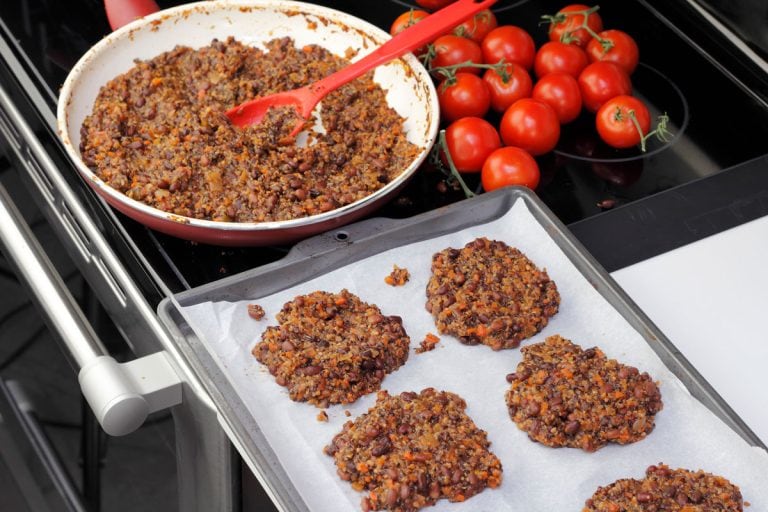 Parchment paper lined cookie sheet with quinoa and three bean patties ready to be cooked, Can You Use A Baking Sheet As A Griddle?