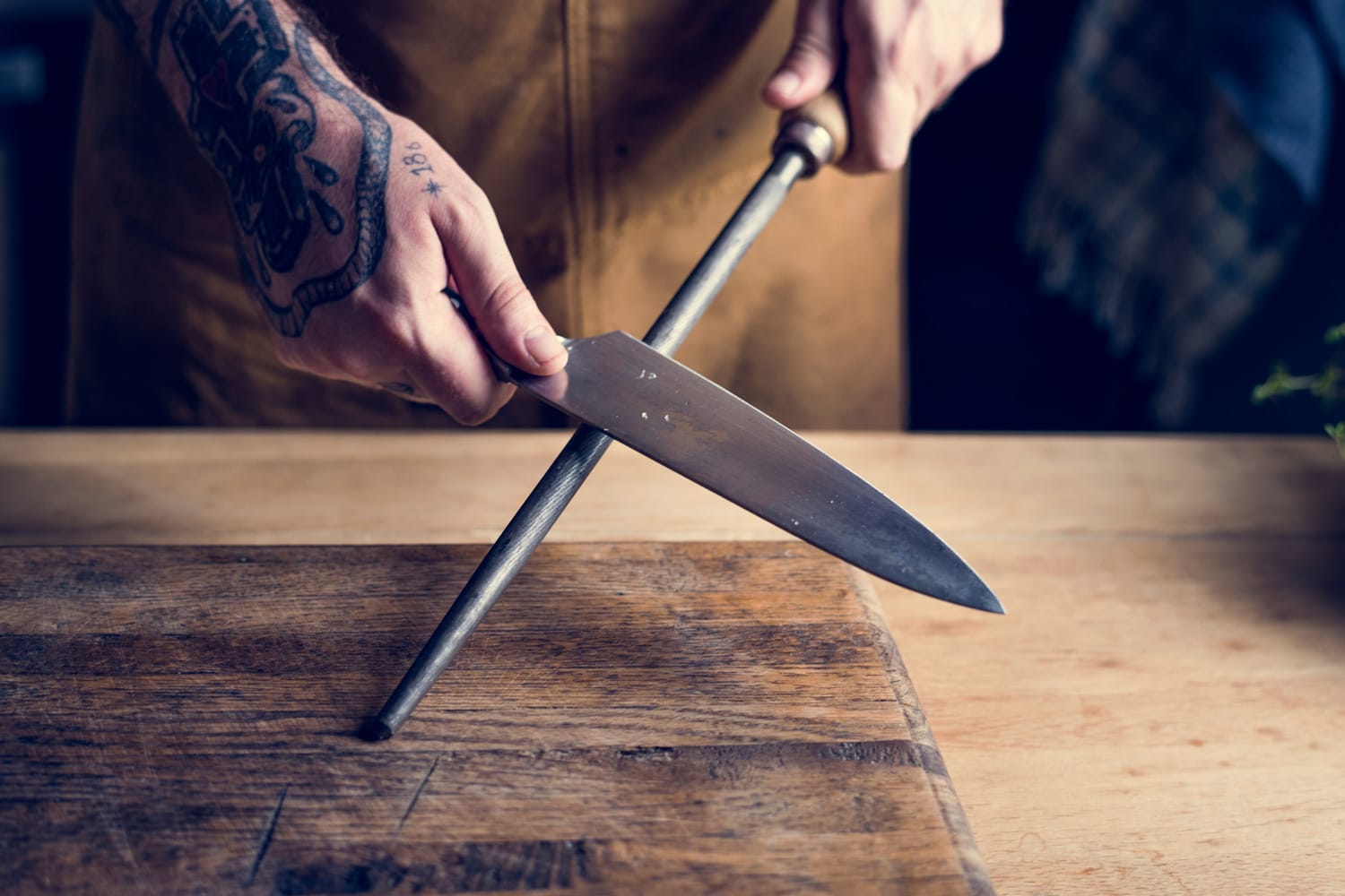 Professional chef sharpening knife in the kitchen