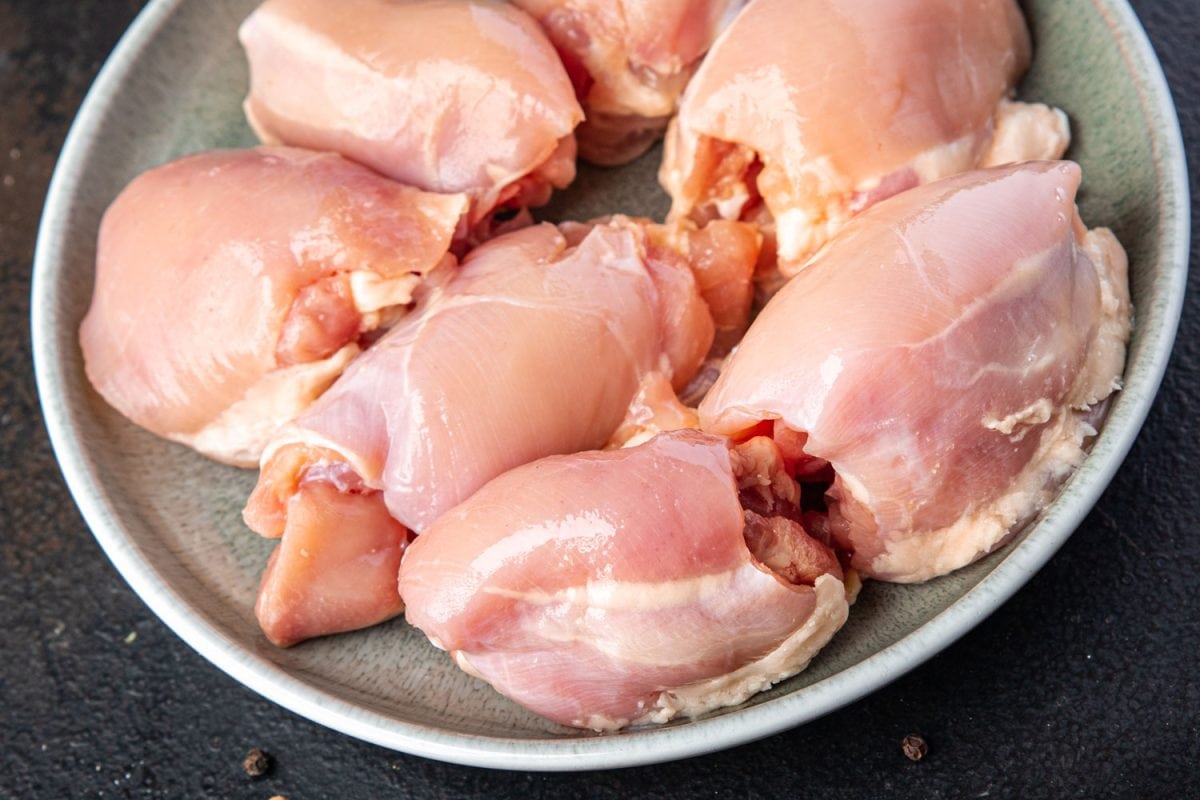 Raw chicken breasts placed on stainless steel tray