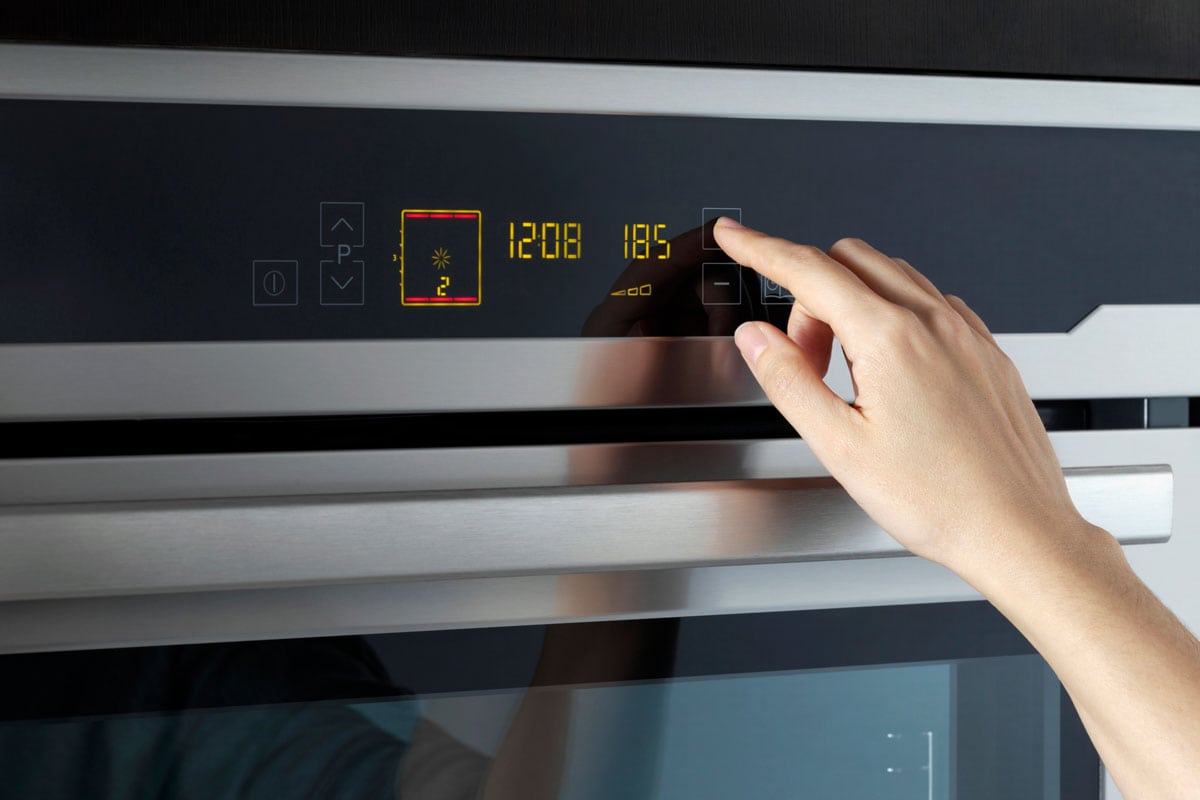 Setting estimated time for baking cake in oven in domestic kitchen