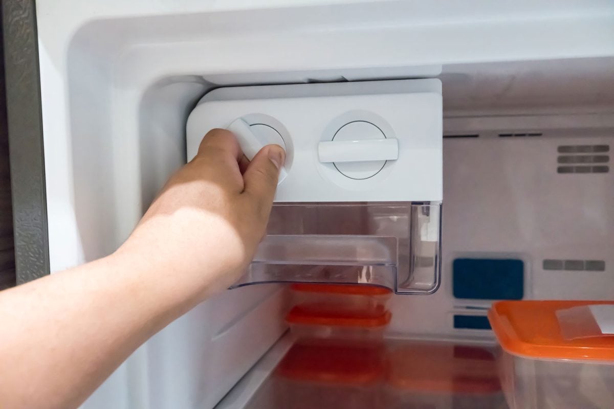Woman changing the refrigerator temperature