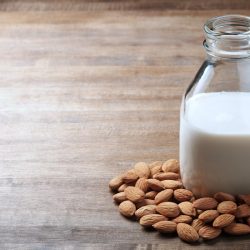 Bottle of almond milk surrounded by almonds, Can You Leave Almond Milk Out Overnight? [And Does It Expire?]