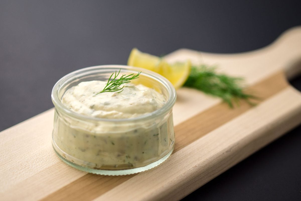 A glass saucer with ranch dressing and oregano
