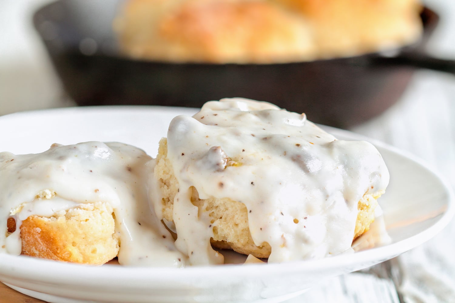 American biscuits from scratch covered with thick white sausage gravy.