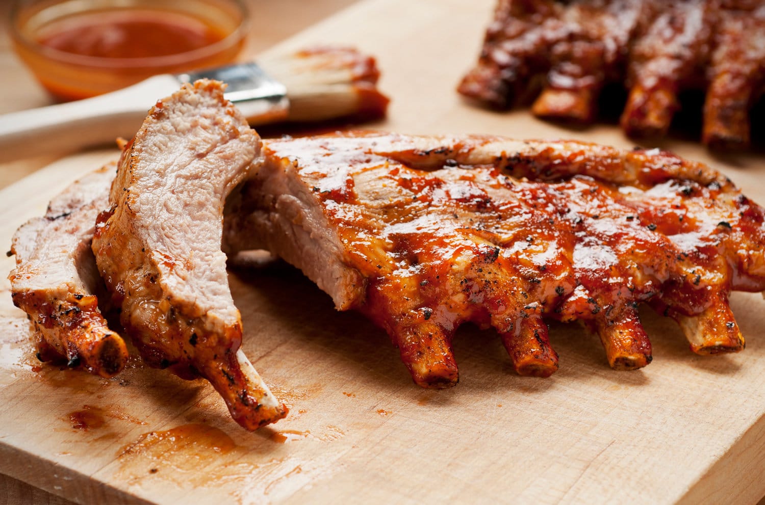 Barbecue ribs with sauce on a cutting board.