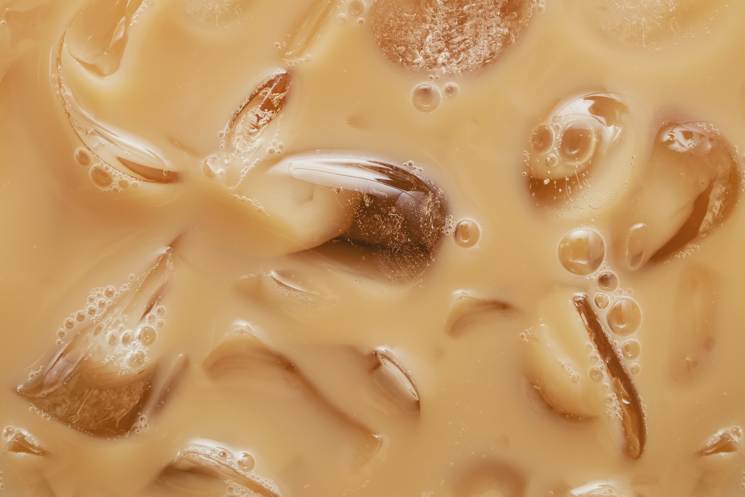 Close-up of Cold latte drink with ice cubes, iced coffee texture.