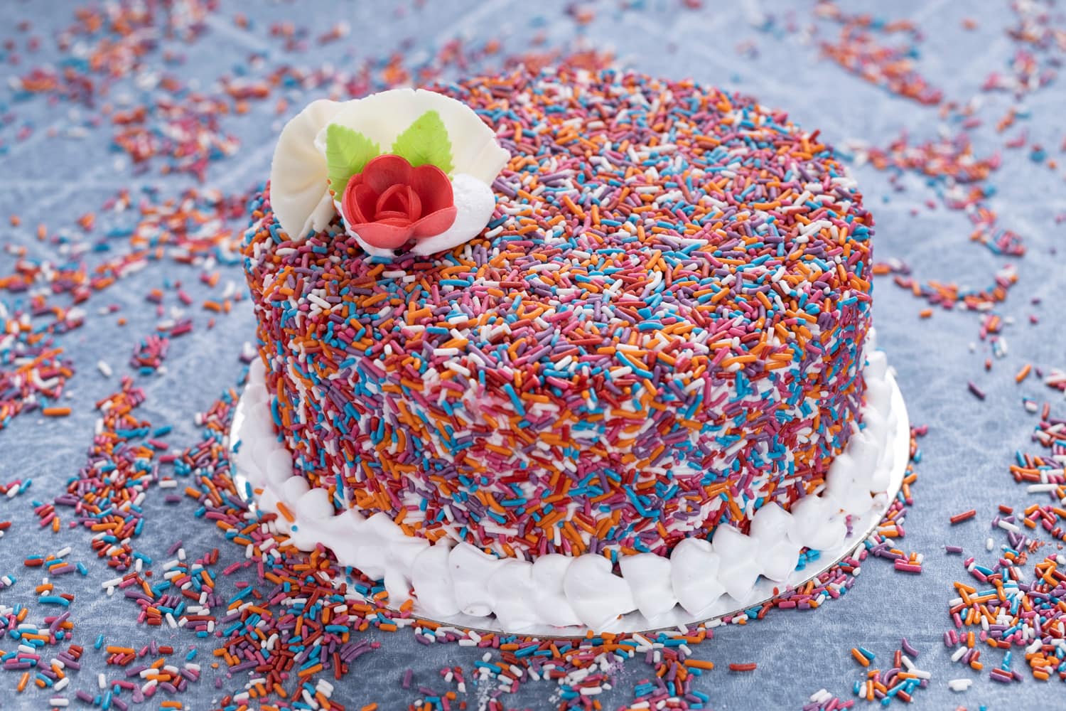 Colorful Rainbow marble cake with sprinkles over a white background