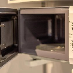 An empty microwave oven with door open, Microwave Oven Vs. Microwave: Are They The Same?