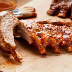 Freshly baked ribs sliced and glazed with a homemade sauce, At What Temperature To Bake Ribs?