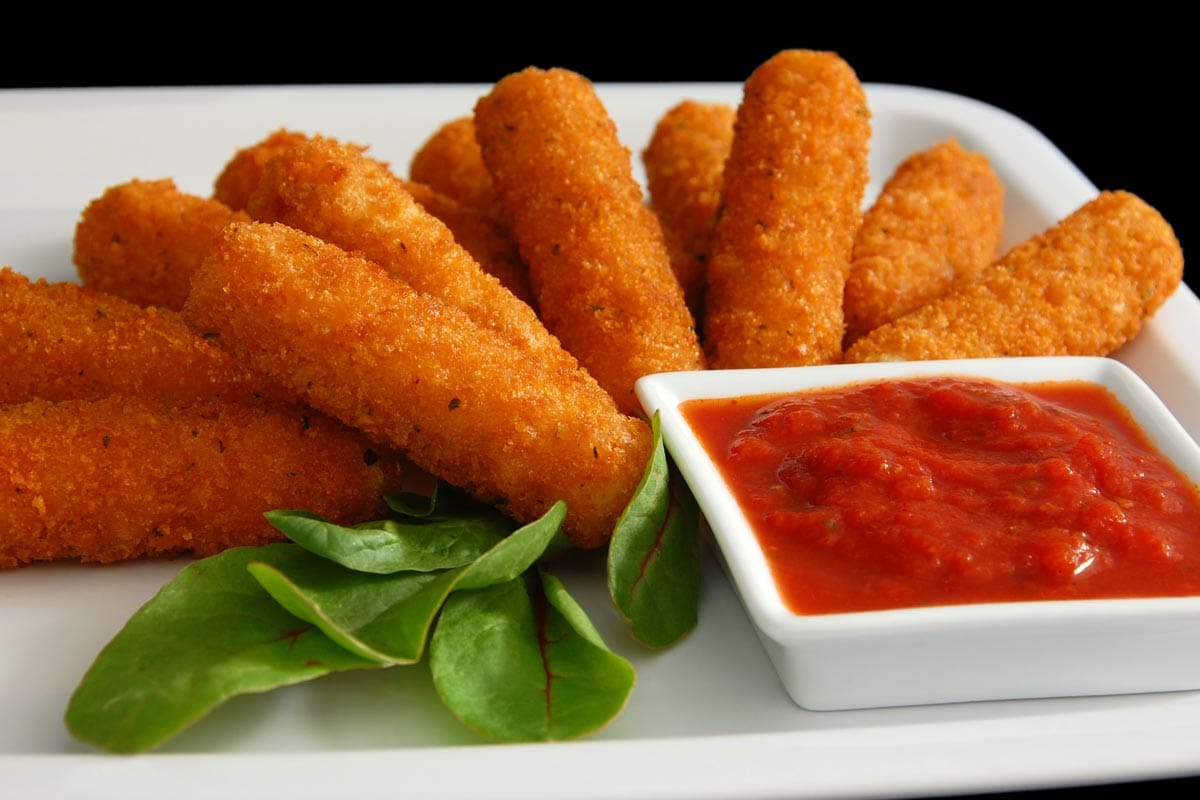 A fried mozzarella sticks with sauce dip and green leaves, How Long Do Cheese Sticks Last?