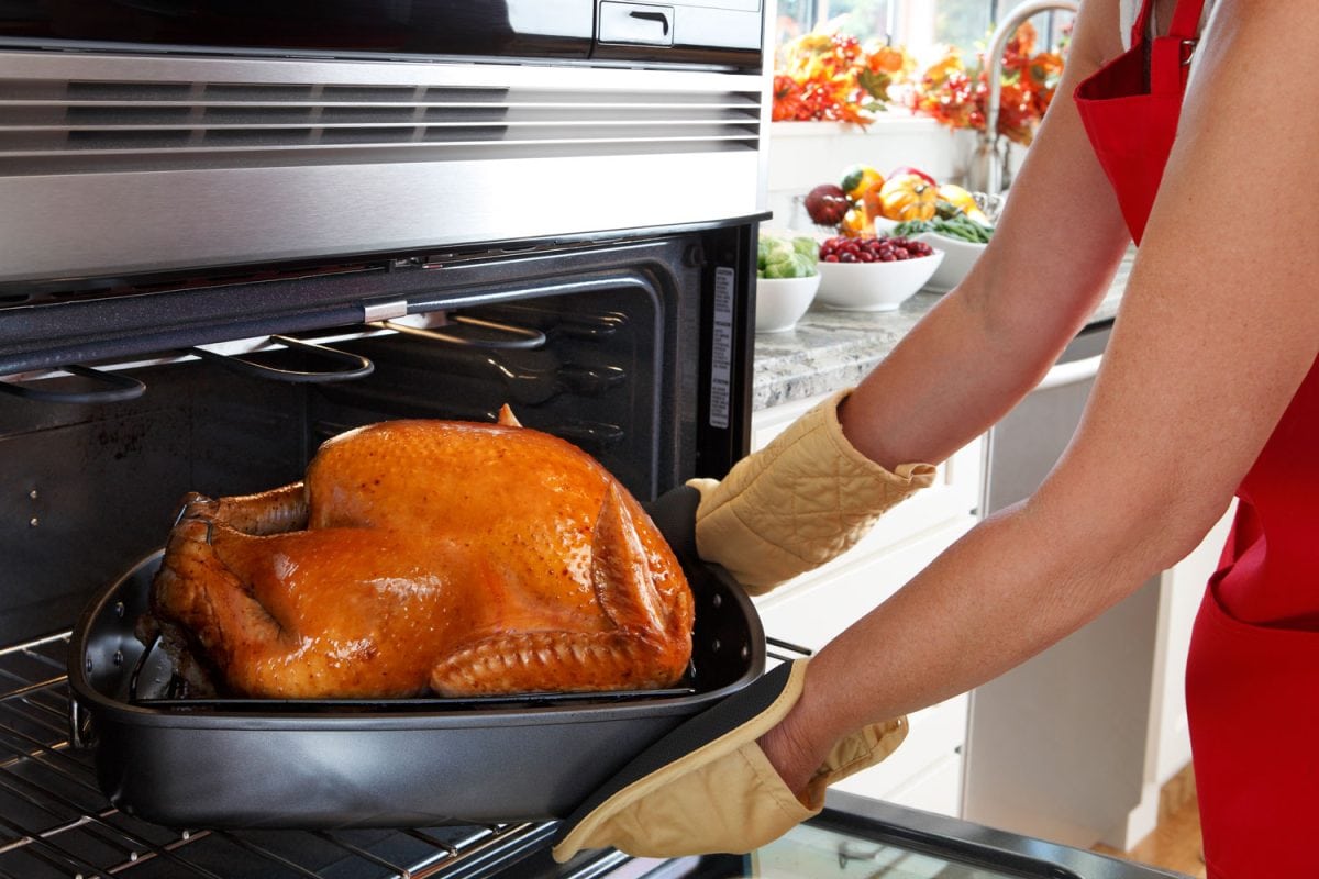 Home cook taking out a delicious oven roasted turkey