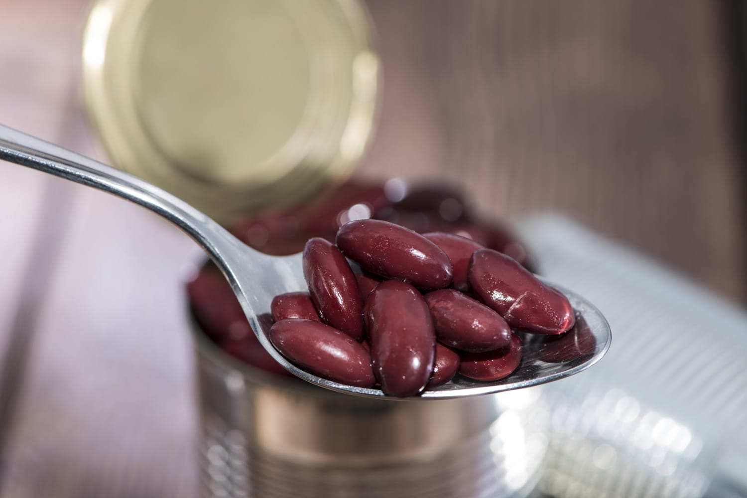 Kidney Beans on a Spoon with blurred cans in the background