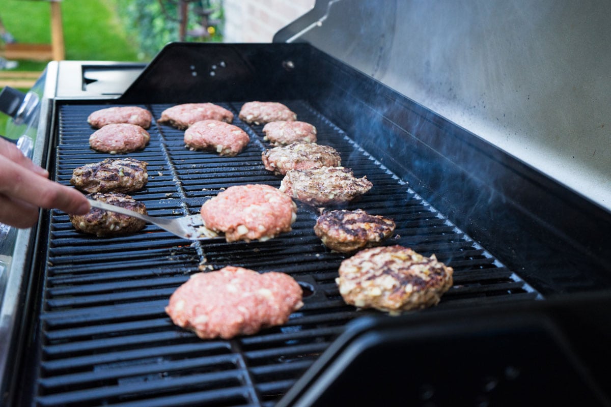 Man Flipping Burgers on Grill