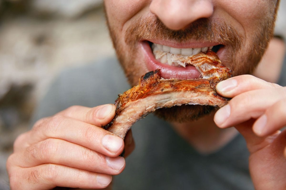 Man eating a tender piece of rib