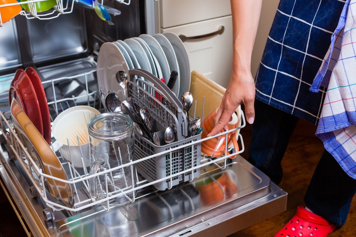 Man removing newly washed dishes from the dishwasher