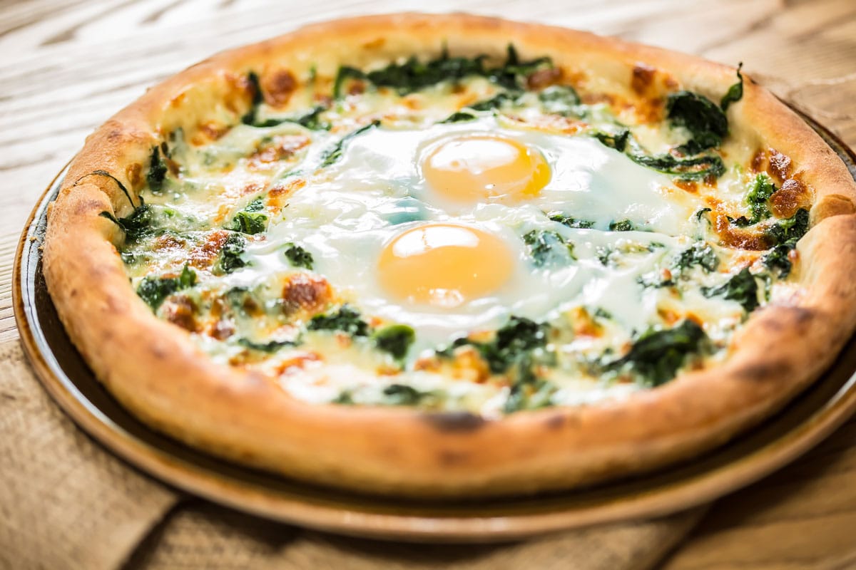 Margarita pizza with arugula and egg for breakfast